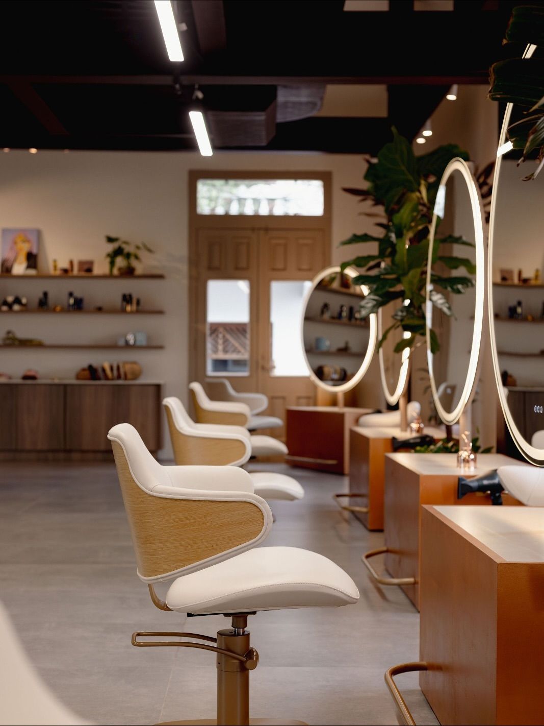 Interior del salón Szabo con espejos redondos y sillas color crema